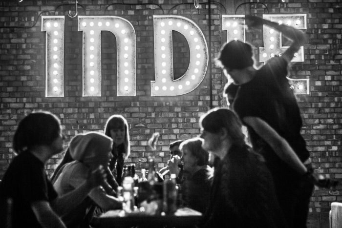 Young people in front of a Cafe Indie sign